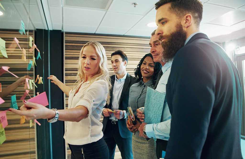 Colleagues sharing ideas on a glass wall