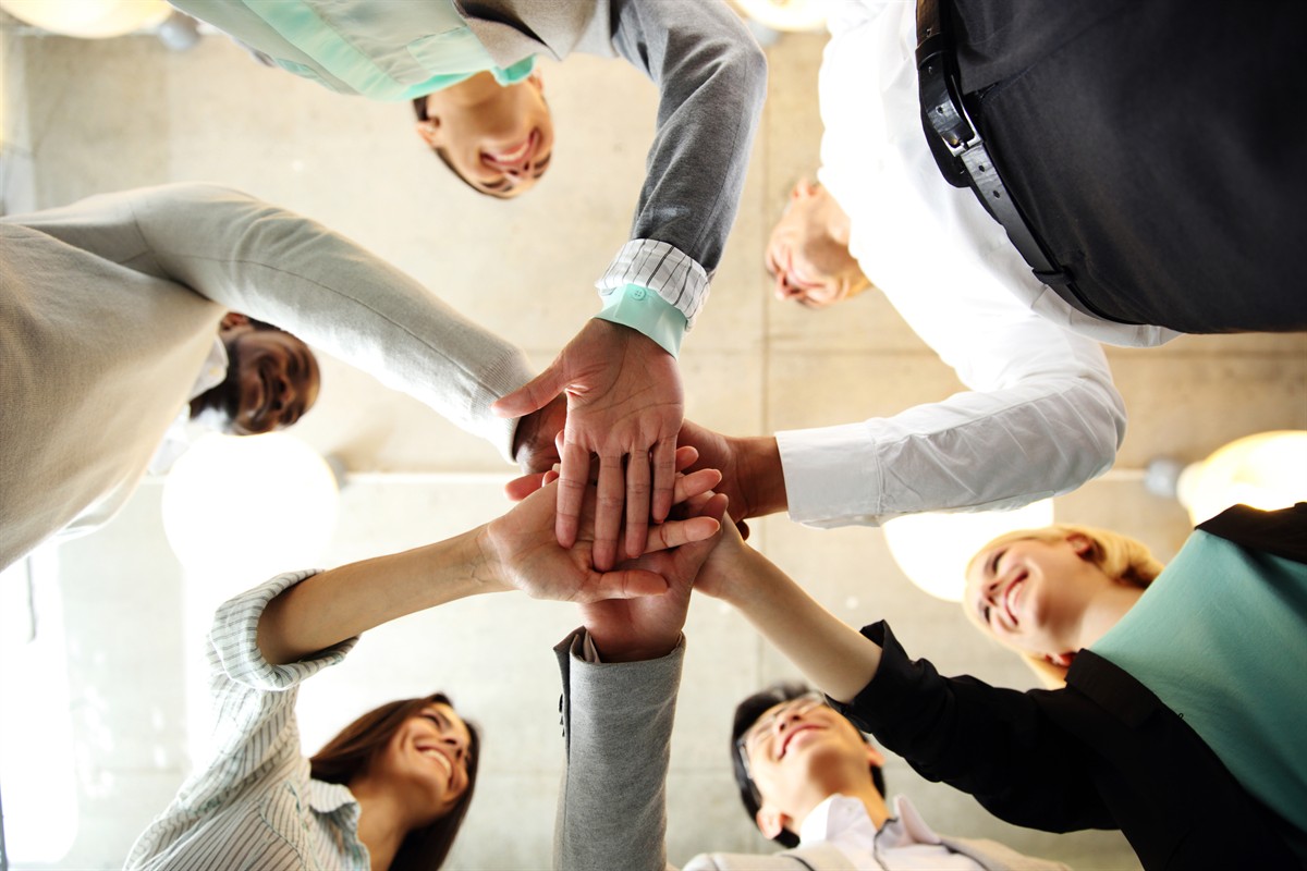 Team members with their hands stacked in the center