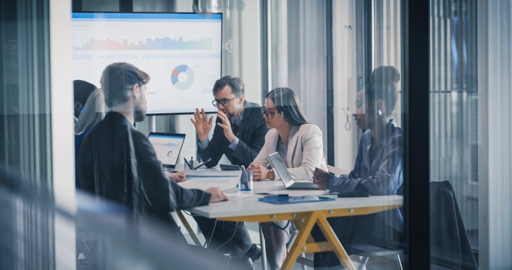 A team reviewing results together around a meeting table.
