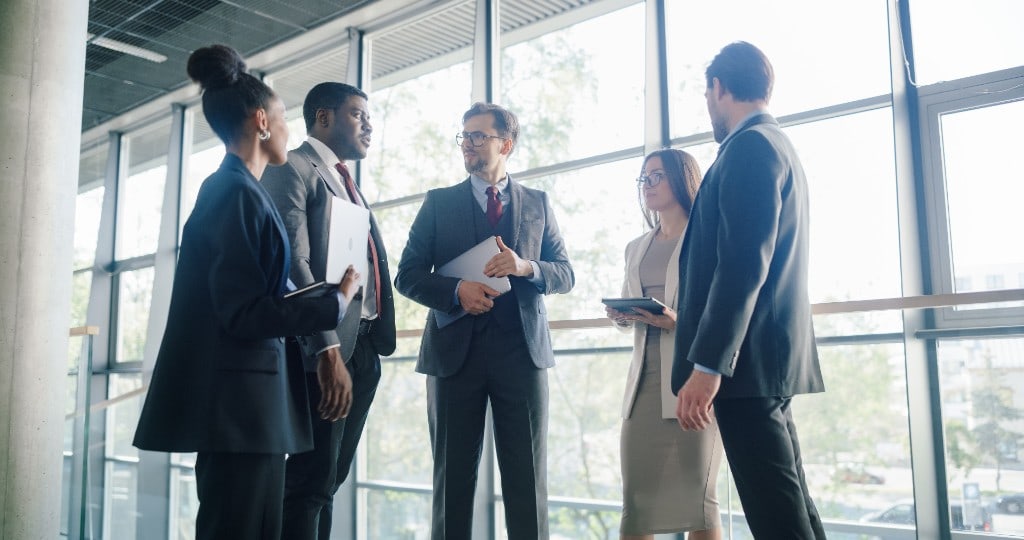 A leadership team talking together in a bright office.