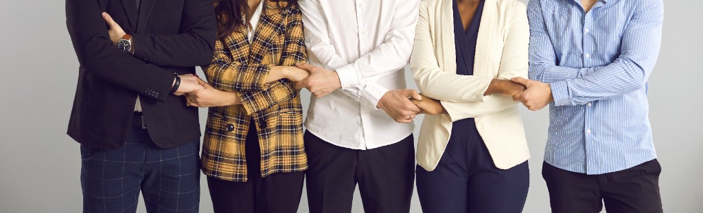 Colleagues standing together with arms linked